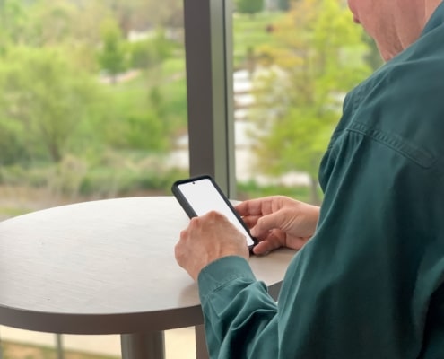 Businessman using mobile device with blank screen mockup friendly