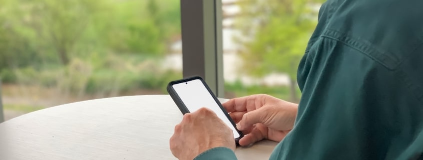 Businessman using mobile device with blank screen mockup friendly