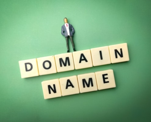 Miniature people and toys word with the word DOMAIN NAME