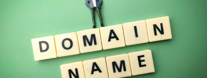 Miniature people and toys word with the word DOMAIN NAME